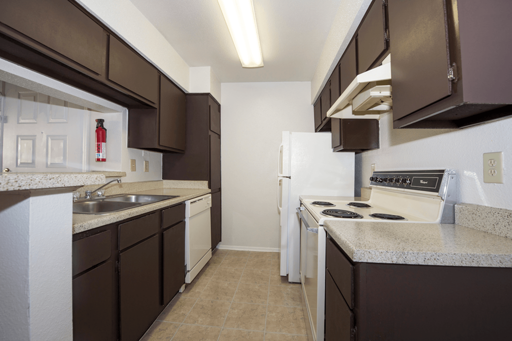 a kitchen with white appliances and brown cabinets and a white refrigerator