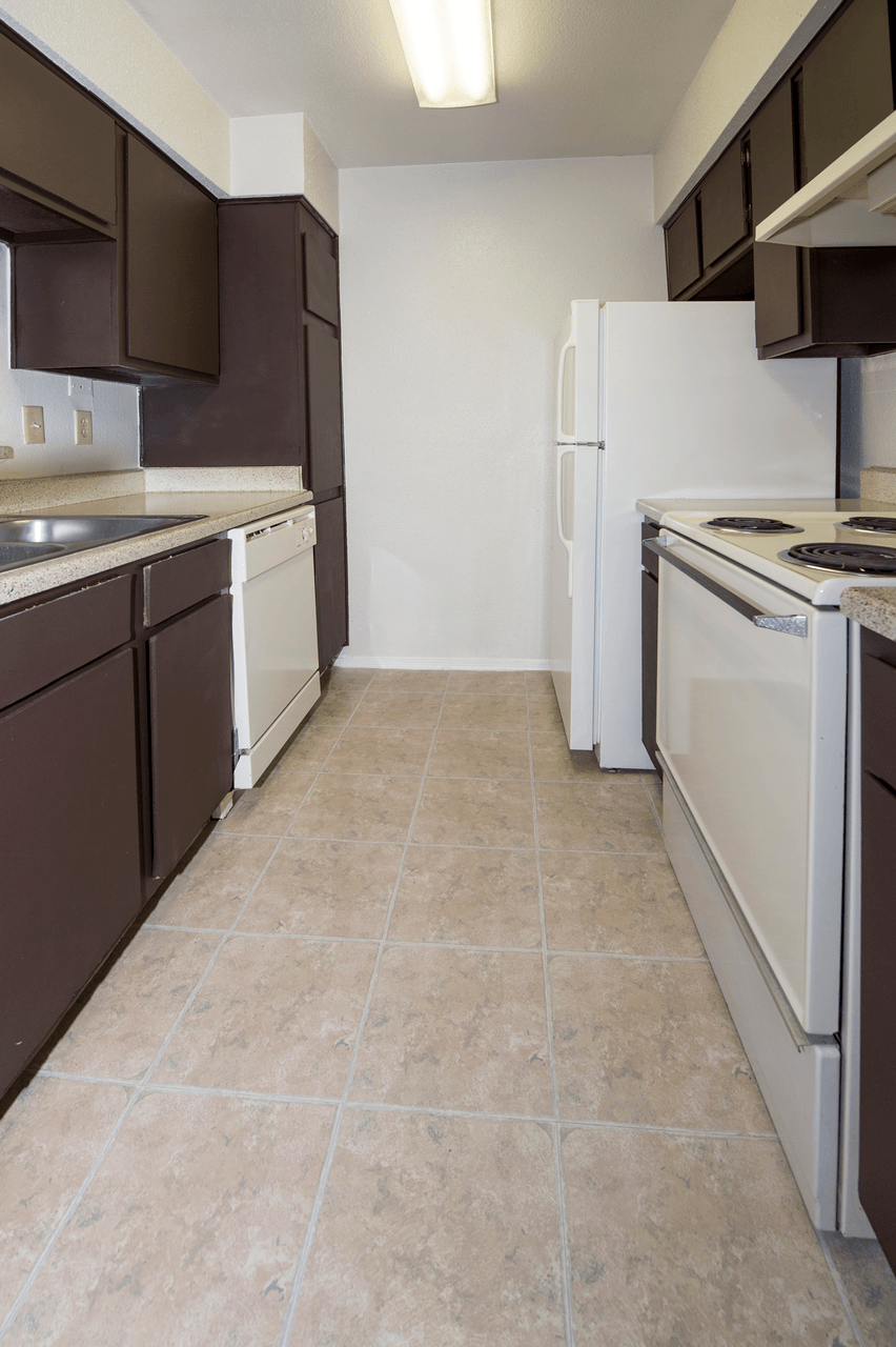 a kitchen with white appliances and brown cabinets and a white refrigerator