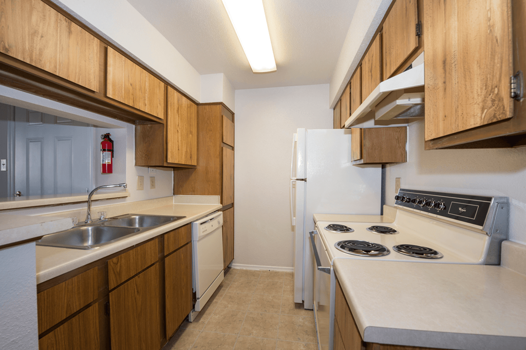 a kitchen with white appliances and wooden cabinets