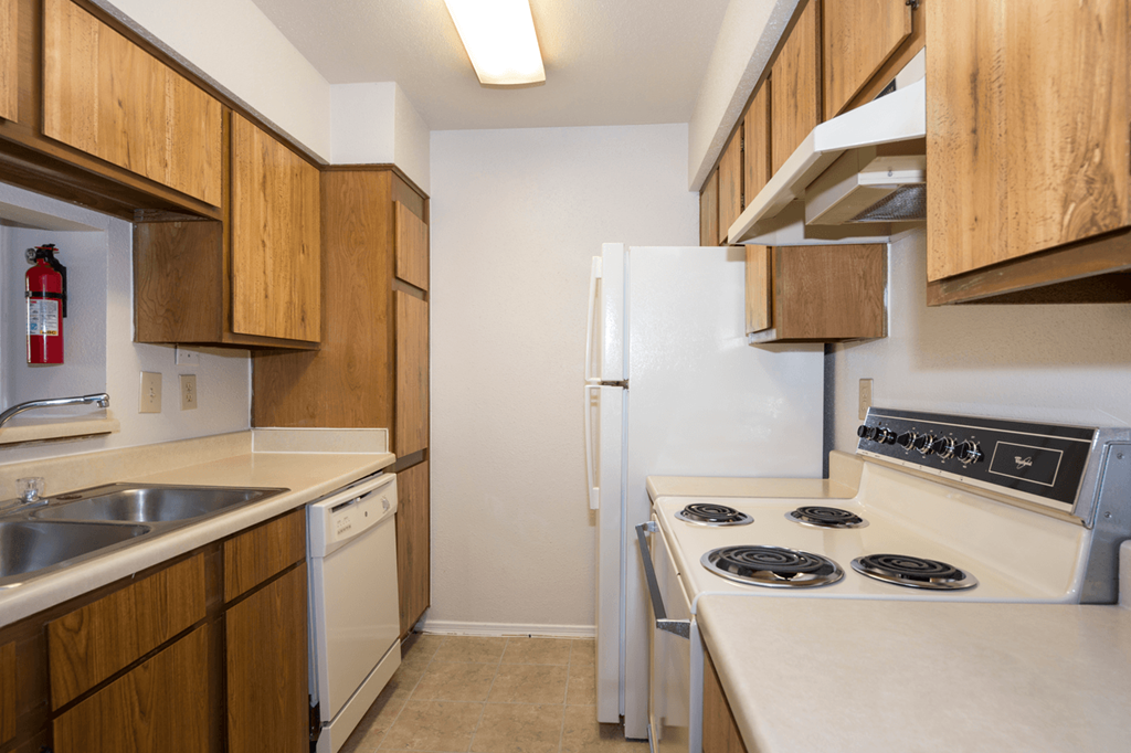 a kitchen with white appliances and wooden cabinets
