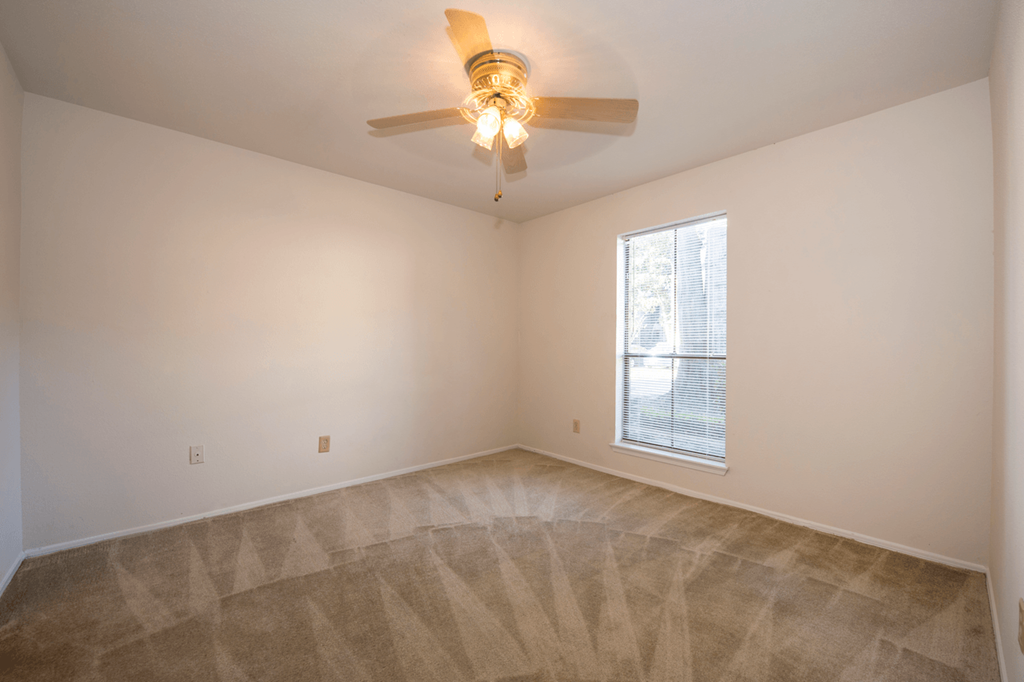 a living room with a ceiling fan and a window