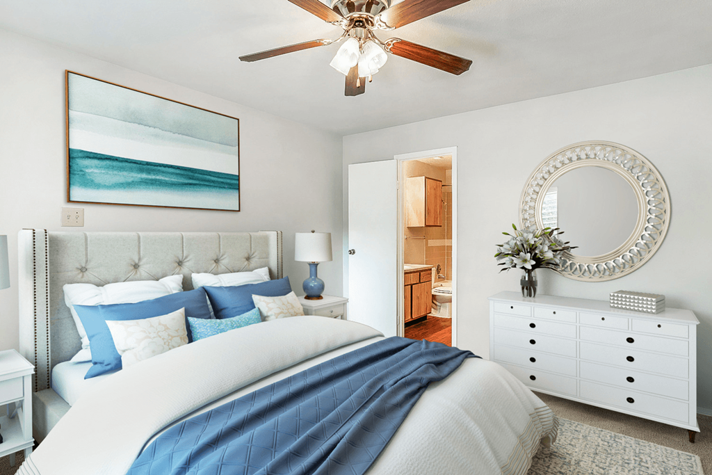 a blue and white bedroom with a bed and a ceiling fan