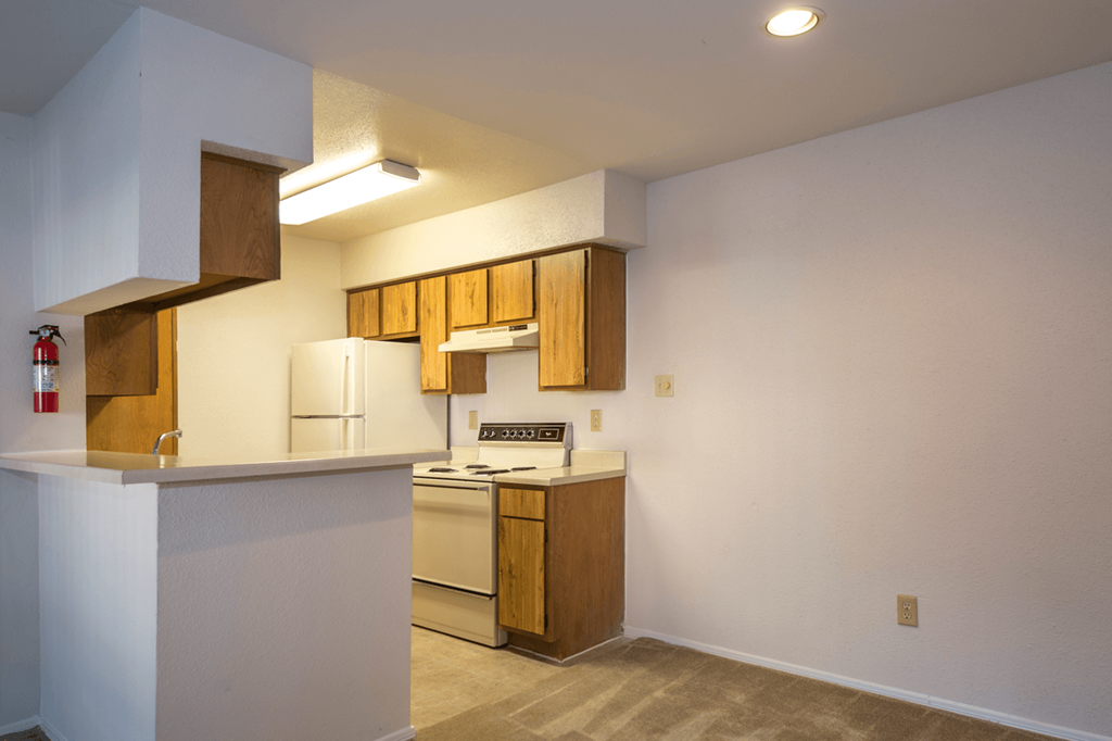 a kitchen with white appliances and wooden cabinets