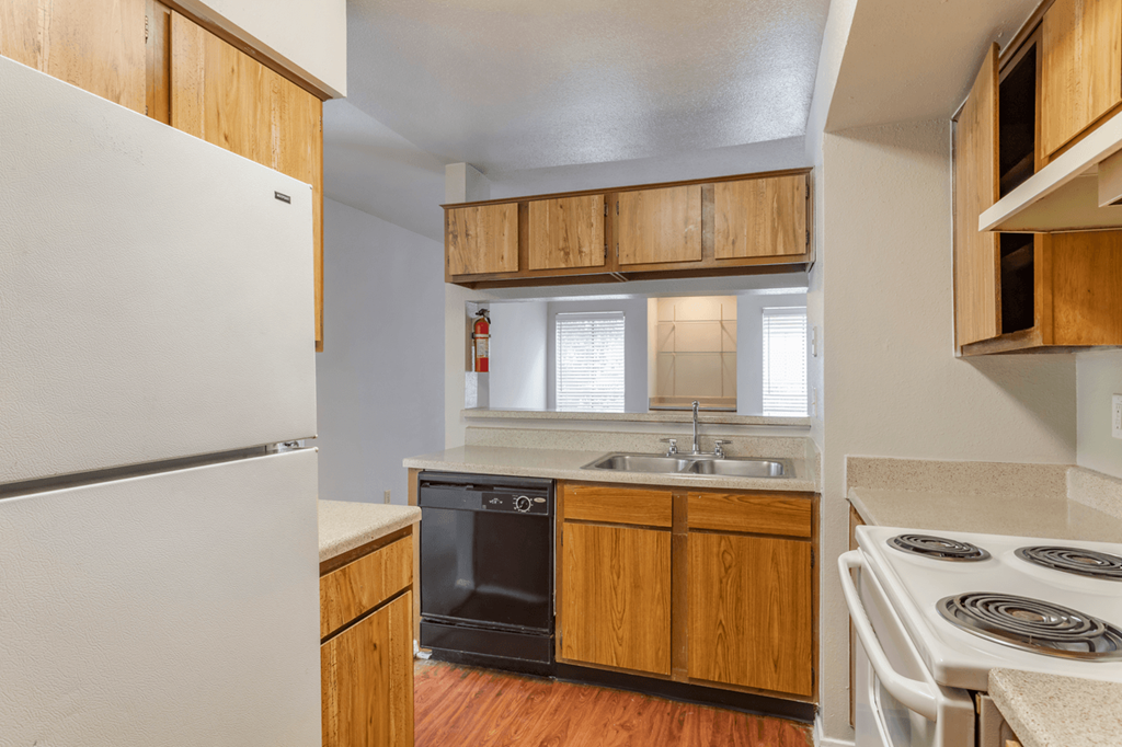 an empty kitchen with a stove refrigerator and sink