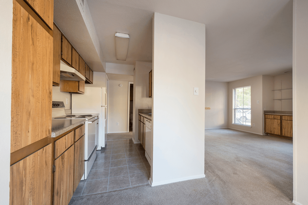 an empty kitchen with a view of the living room