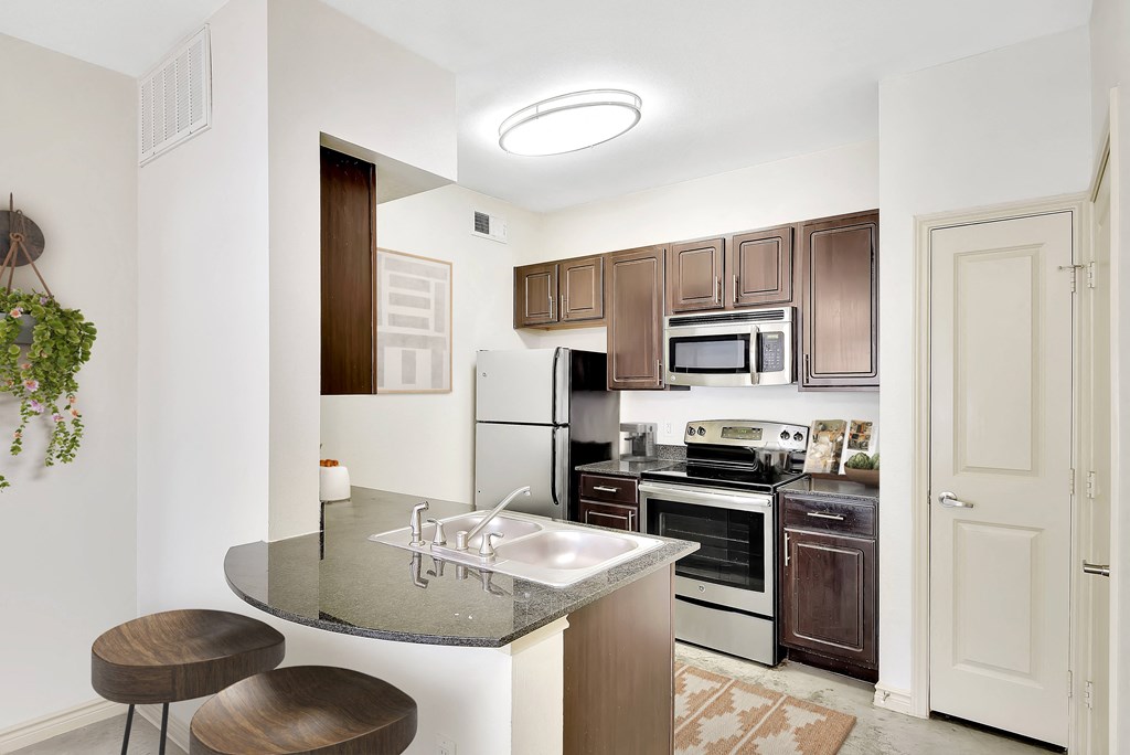 a kitchen with an island with a sink and two stools