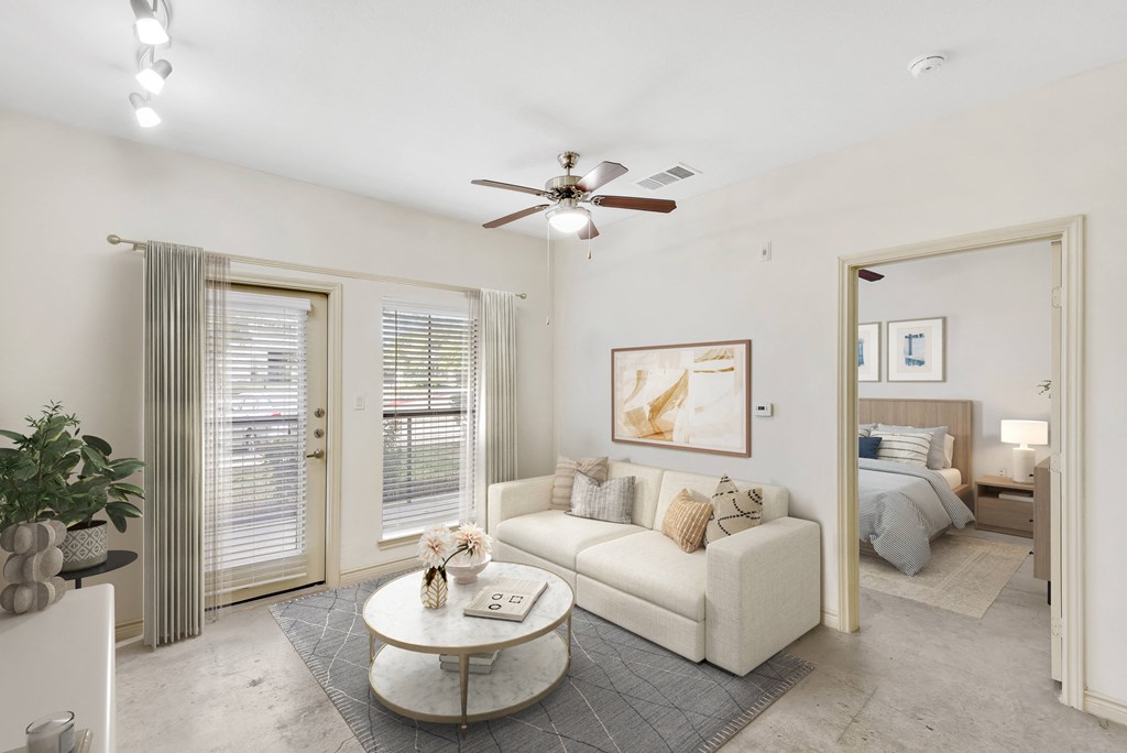 a living area with a couch coffee table and a ceiling fan