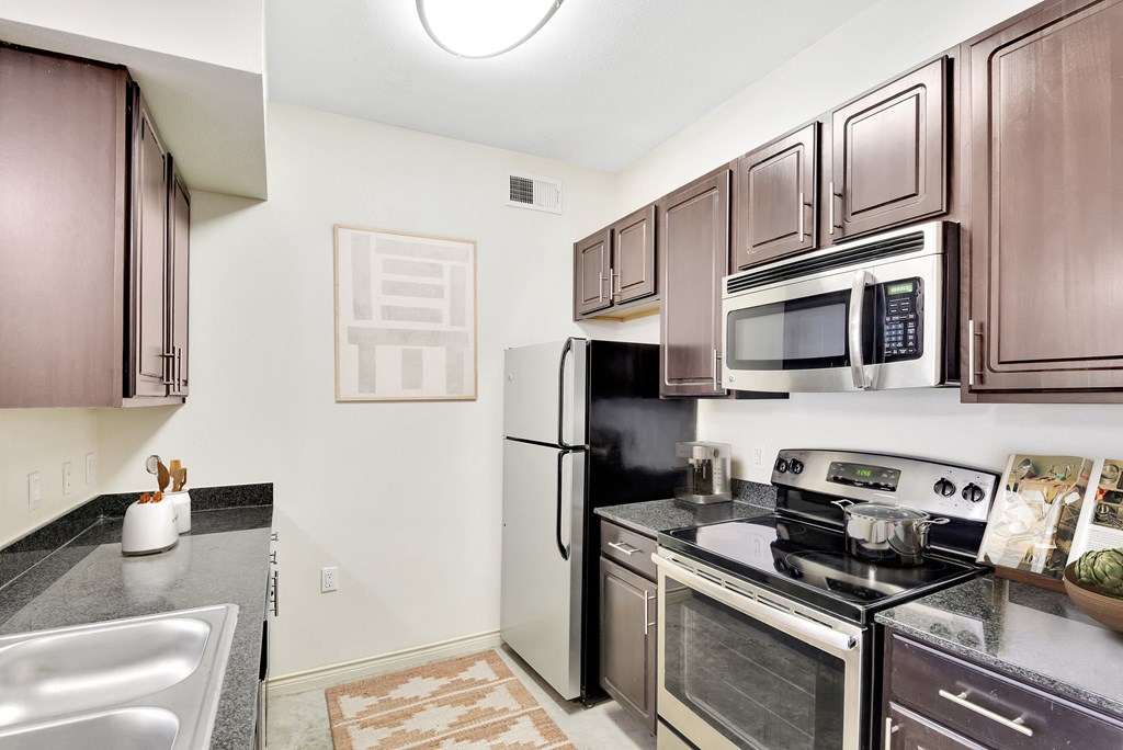 a kitchen with wooden cabinets and stainless steel appliances