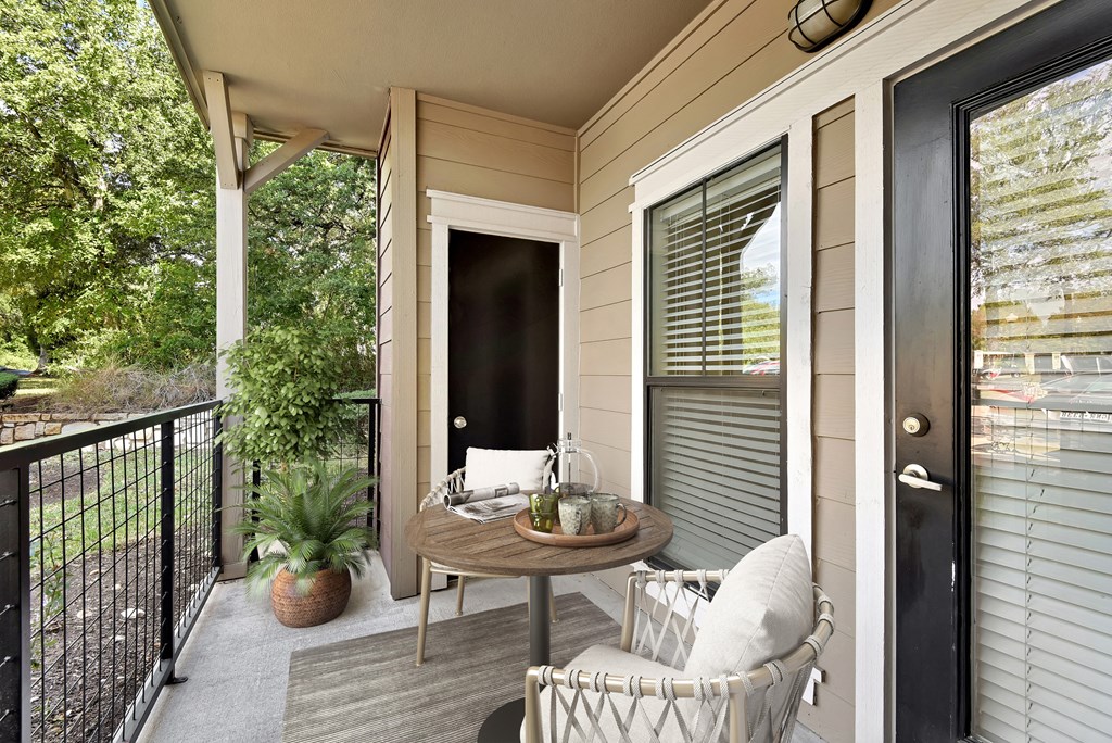 a porch with a table and two chairs