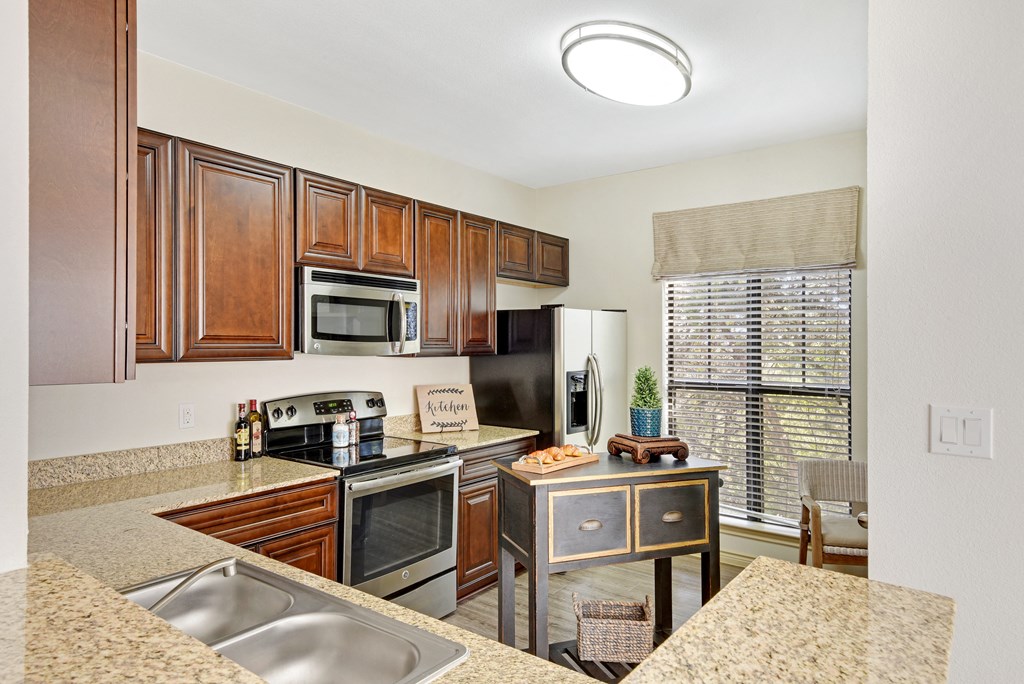 a kitchen with granite countertops and stainless steel appliances