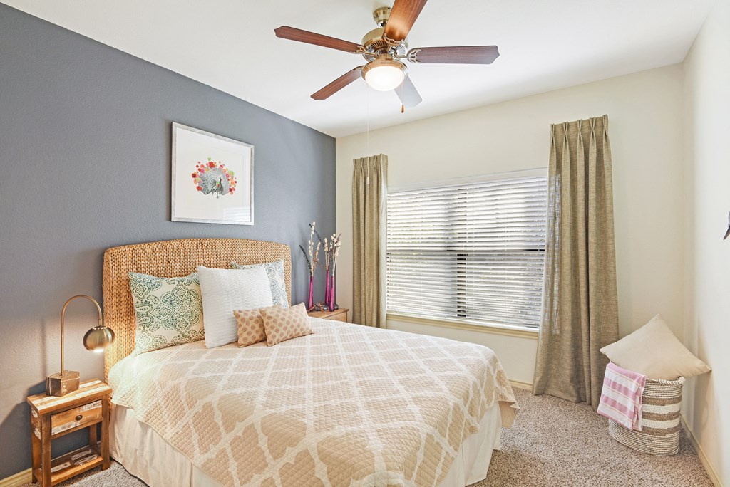 a bedroom with a bed and a ceiling fan