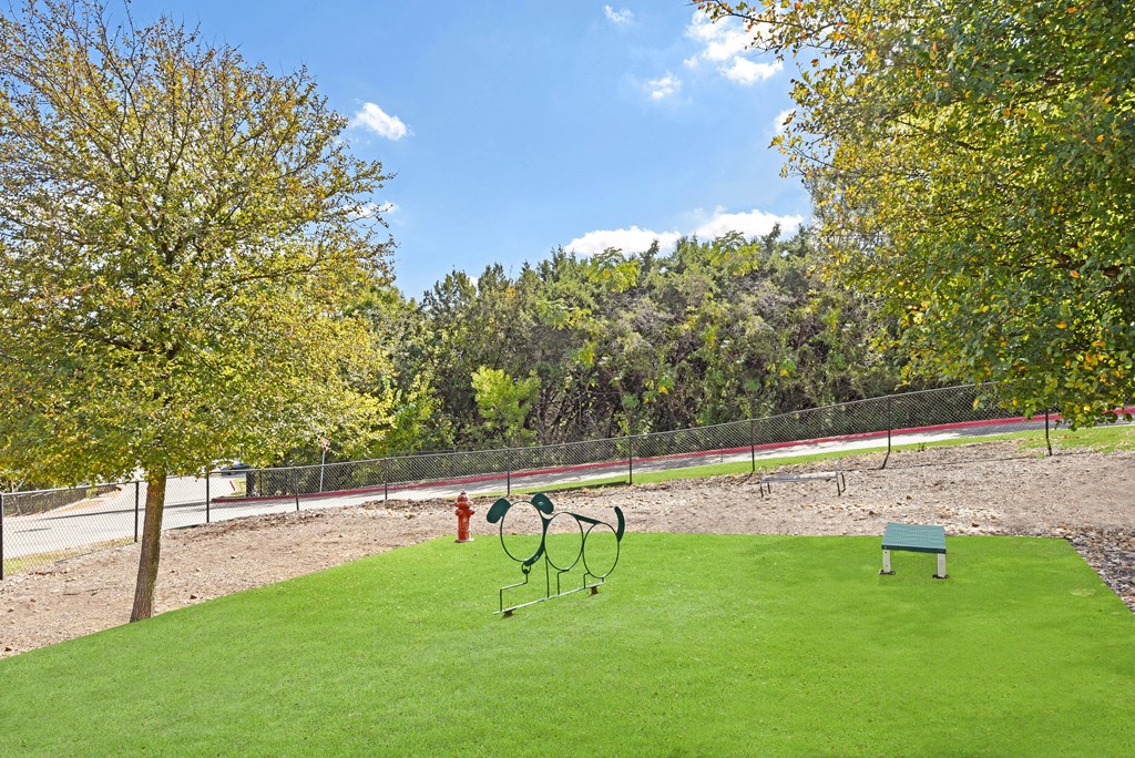 a grassy area with a bench and a fire hydrant