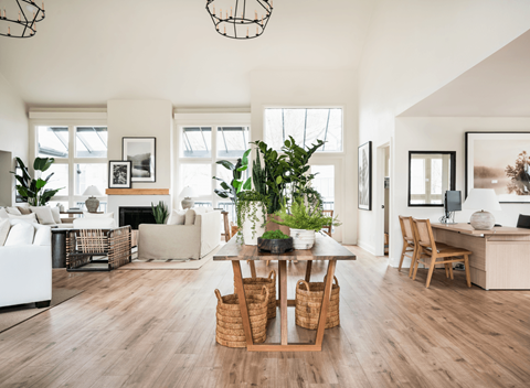 A living room with a white sofa, a wooden dining table with chairs, and a fireplace with a mantelpiece.