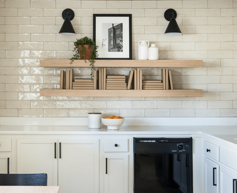 A kitchen with a black oven and white cabinets.