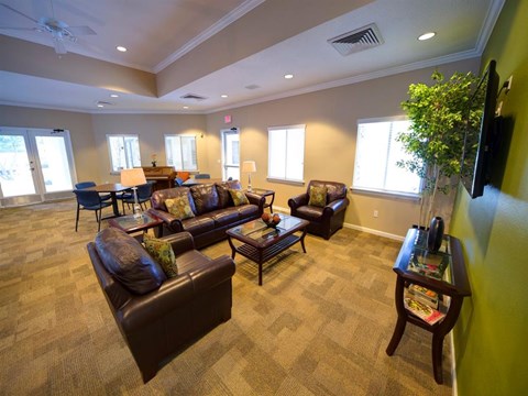 A living room with brown leather couches and a carpeted floor.