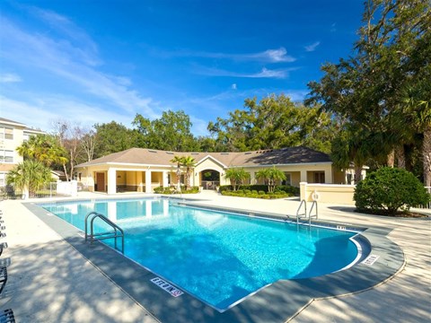 A swimming pool with a slide in front of a house.