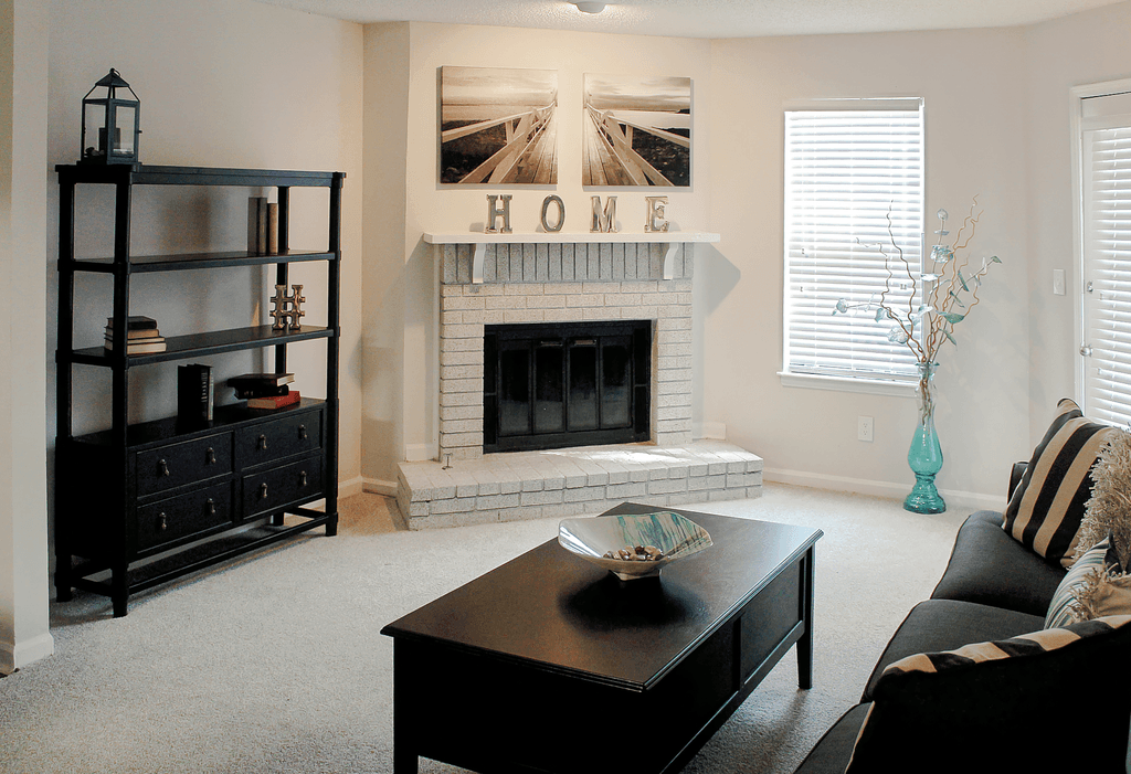 a living room with a fireplace and a coffee table