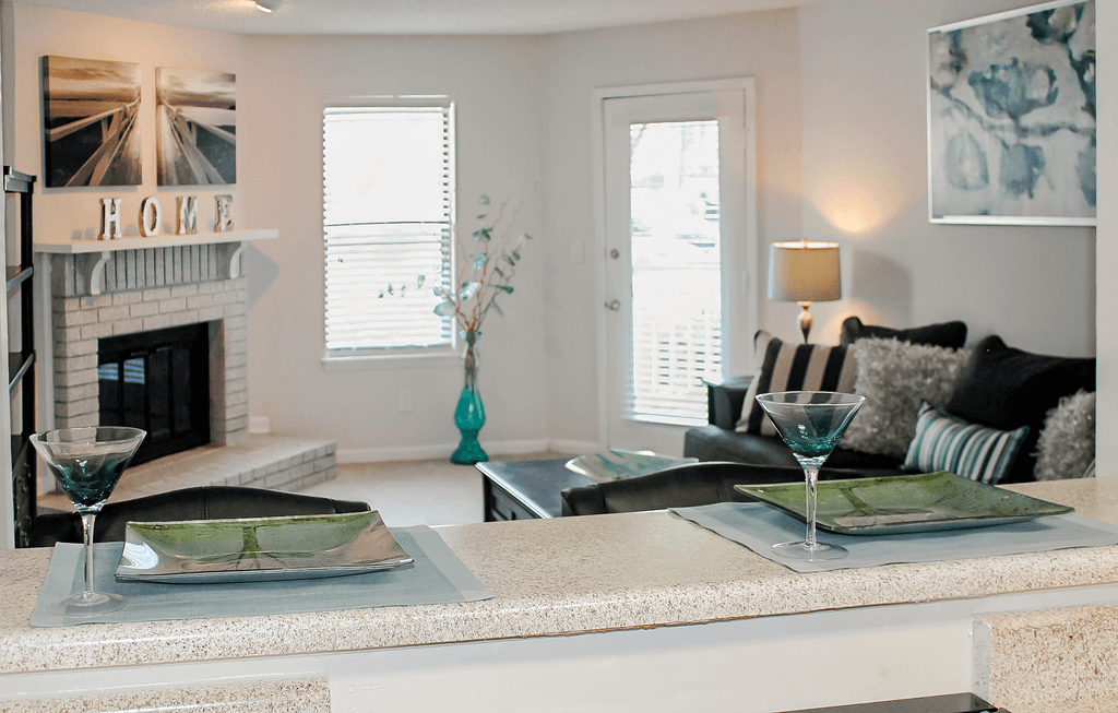a living room with a fireplace and a counter with plates on it