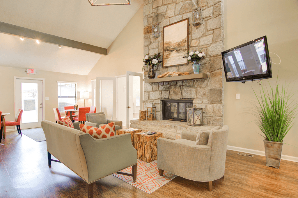 a living room with a stone fireplace and a tv