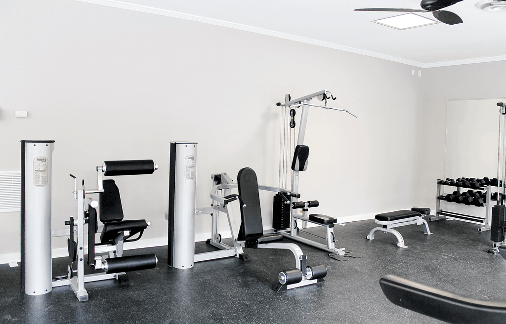a gym with various machines and weights on the floor