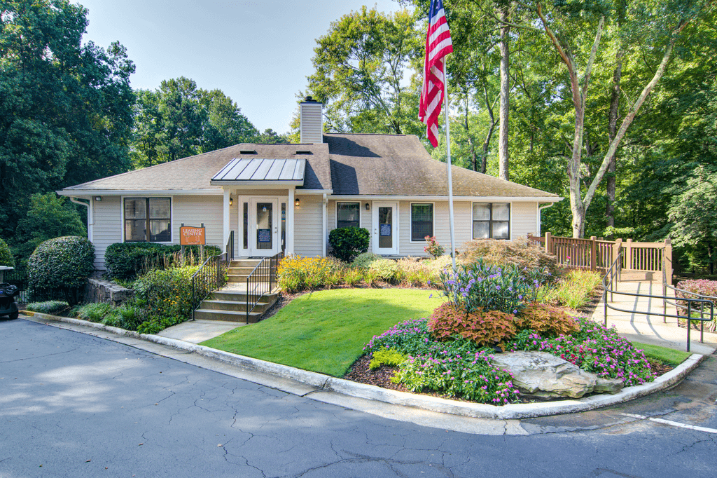 a small white house with an flag in the front yard
