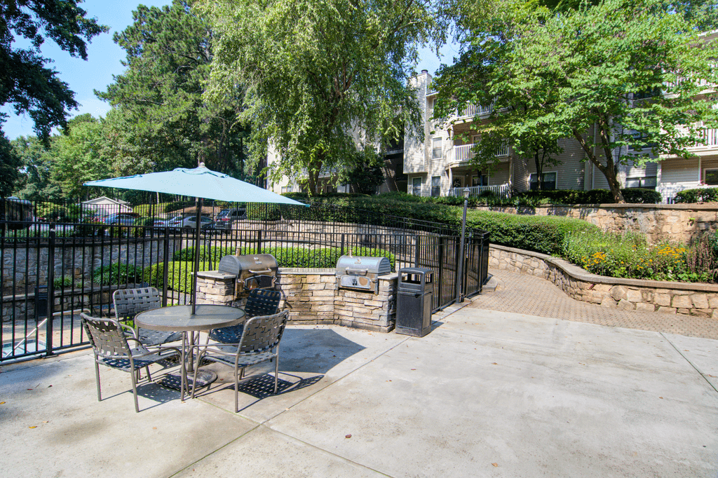 a patio with tables and chairs in front of a fence
