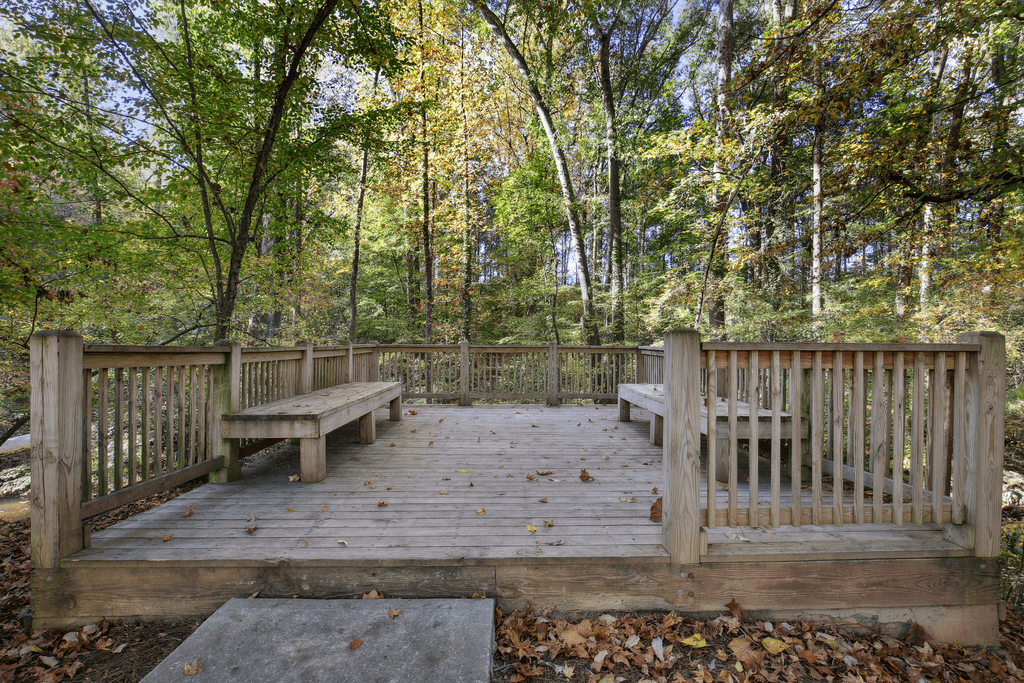 two benches on a wooden deck in the woods
