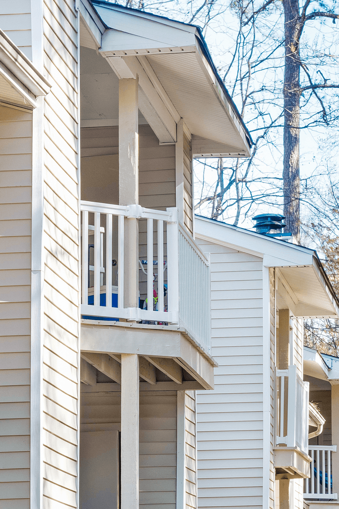 the side of a white house with a balcony