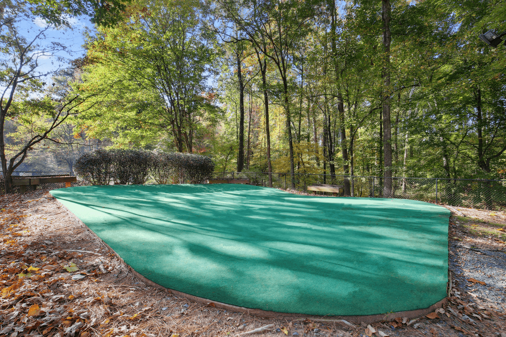 the swimming pool is covered with a green blanket in the woods