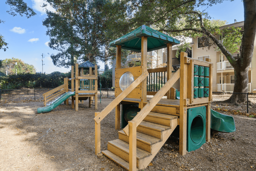 a playground with two slides and stairs in a park
