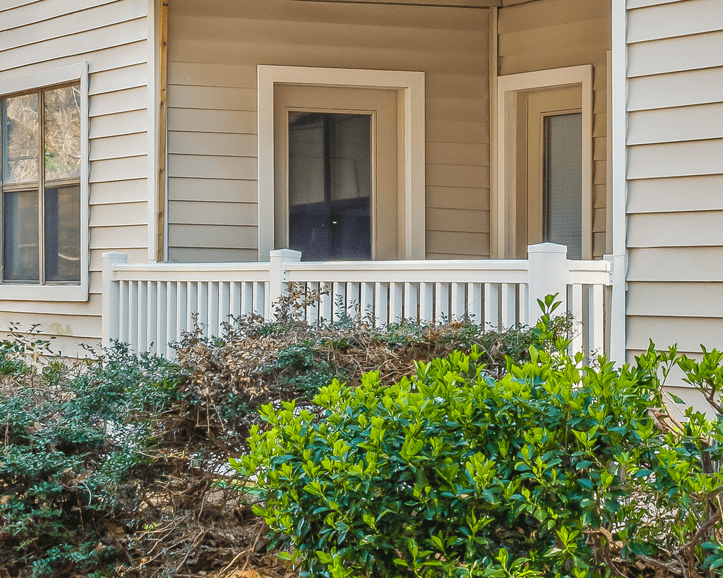 the front porch of a house with a porch swing
