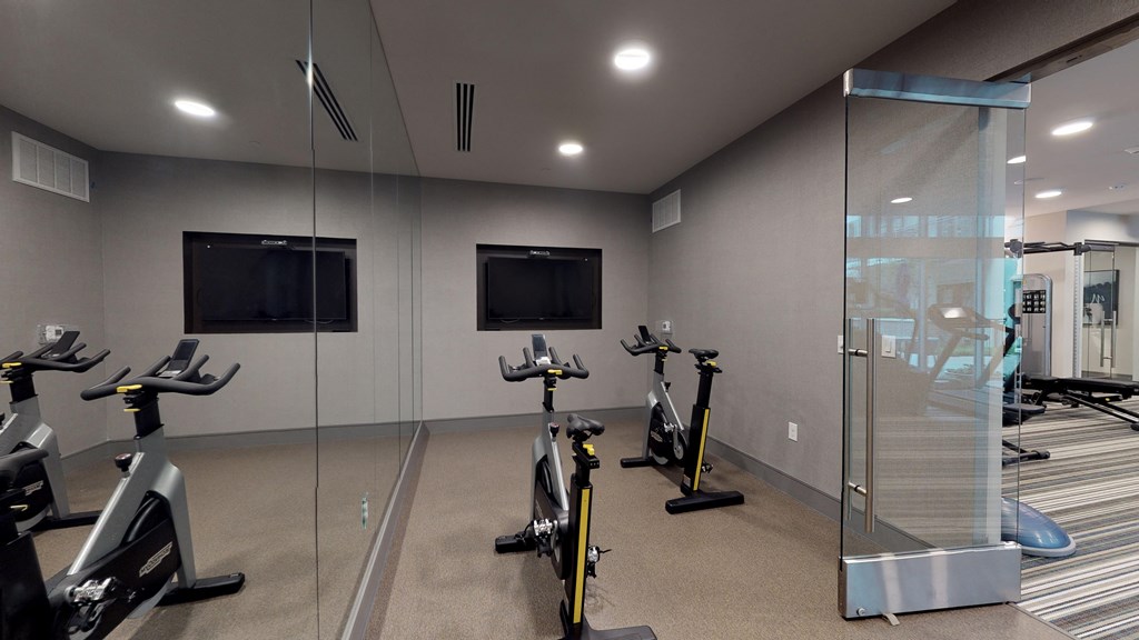 Spin/flex studio facing two exercise bicycles and a large mirror.