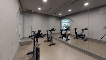 Spin/flex studio facing three exercise bicycles and a large mirror. - Photo Gallery 94