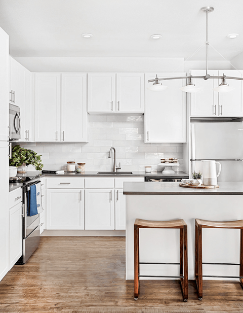 A kitchen with white cabinets and a white counter top.