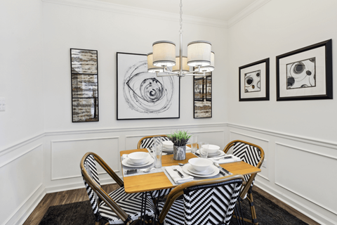 a dining room with a table and chairs and pictures on the wall