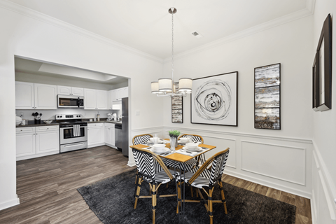 A modern kitchen with a dining table set for two.