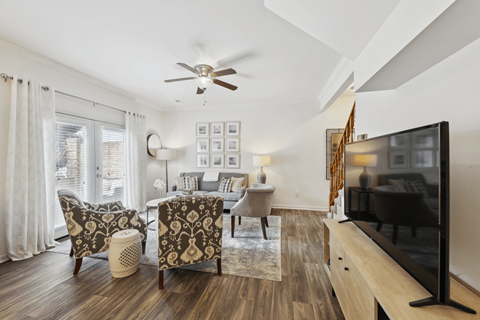 A living room with a television and a fan.