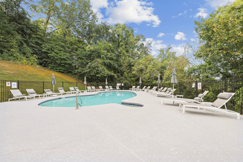 a resort style pool with white chairs and umbrellas