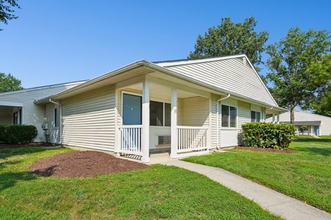 A small house with a porch and a small front yard.