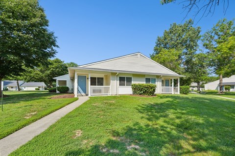 A house with a blue door and white fence.