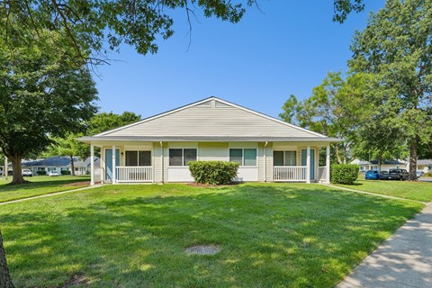 A house with a grey roof and a green lawn.