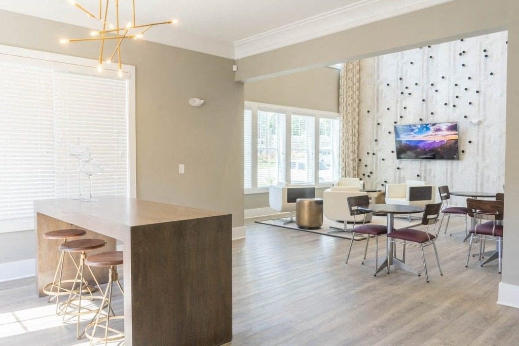 A modern kitchen with a bar area and a dining table set up at Foxwood Apartments, North Carolina