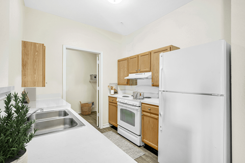 a kitchen with white appliances and wooden cabinets