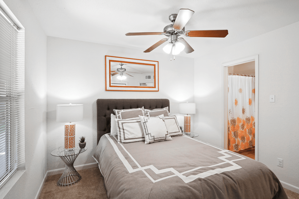 a bedroom with a bed and a ceiling fan
