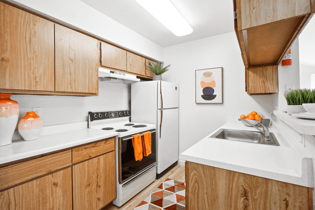 a kitchen with white countertops and wooden cabinets