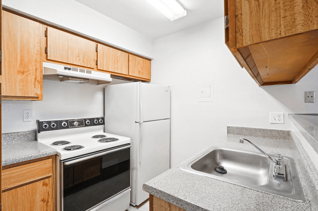 a kitchen with wood cabinets and white appliances