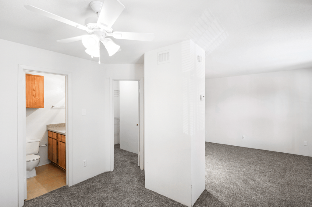 a bedroom with a bed and a ceiling fan