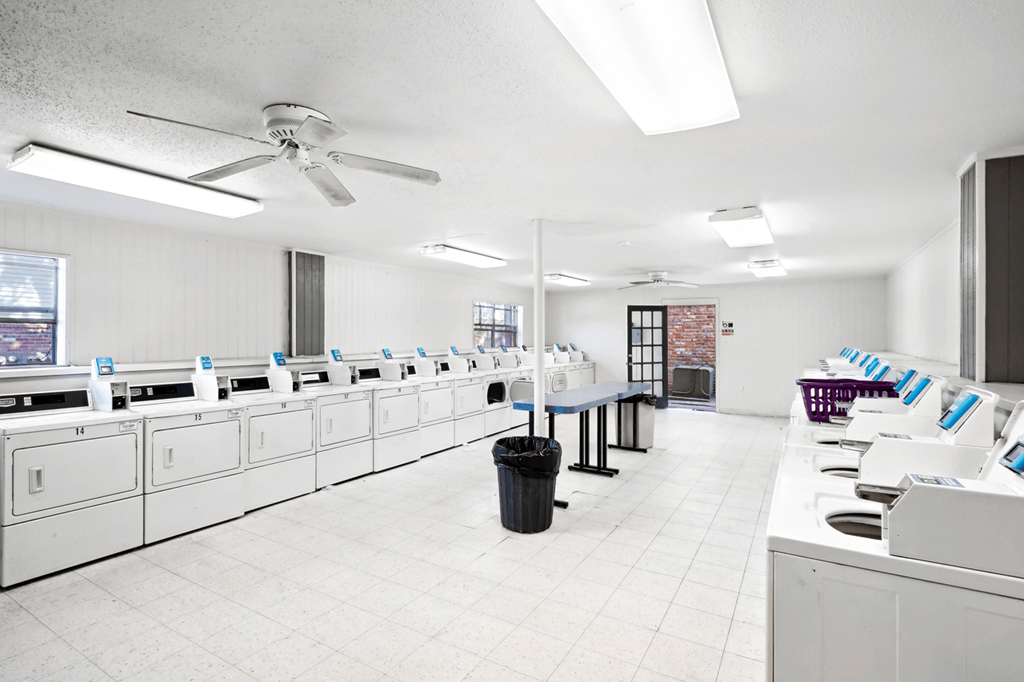 a large laundry room with washers and dryers