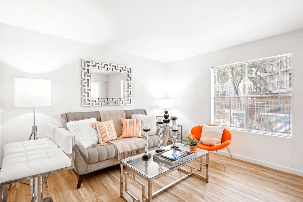 a living room with white walls and hardwood floors