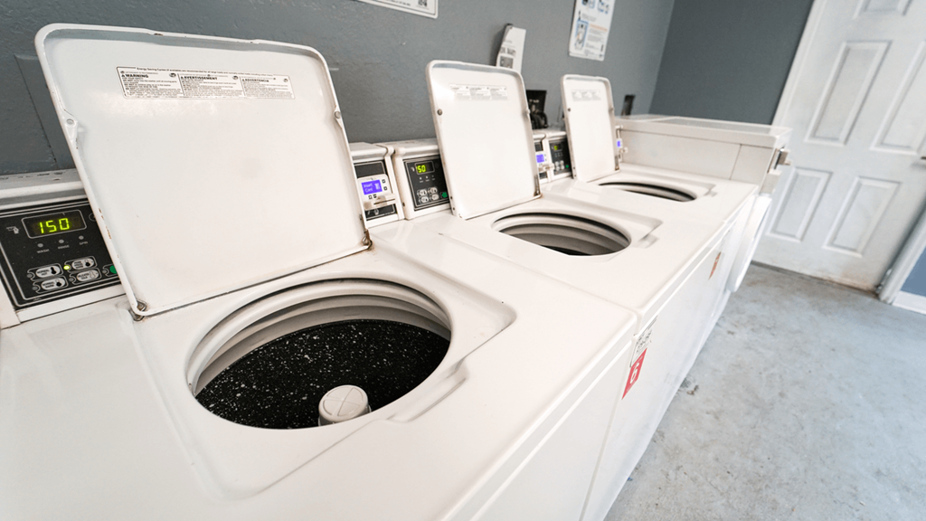 a row of washers and dryers in a laundry room
